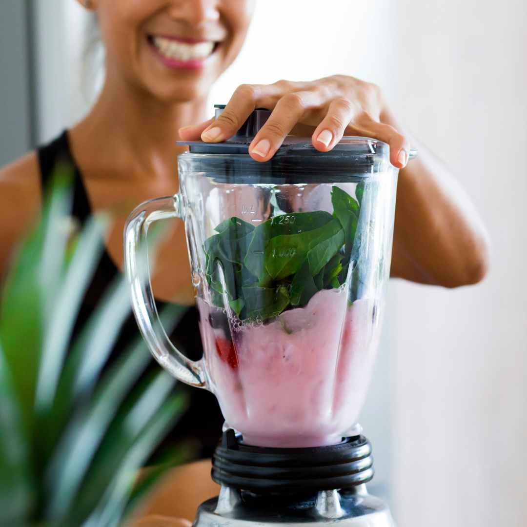 Femme souriante avec blender pour smoothie