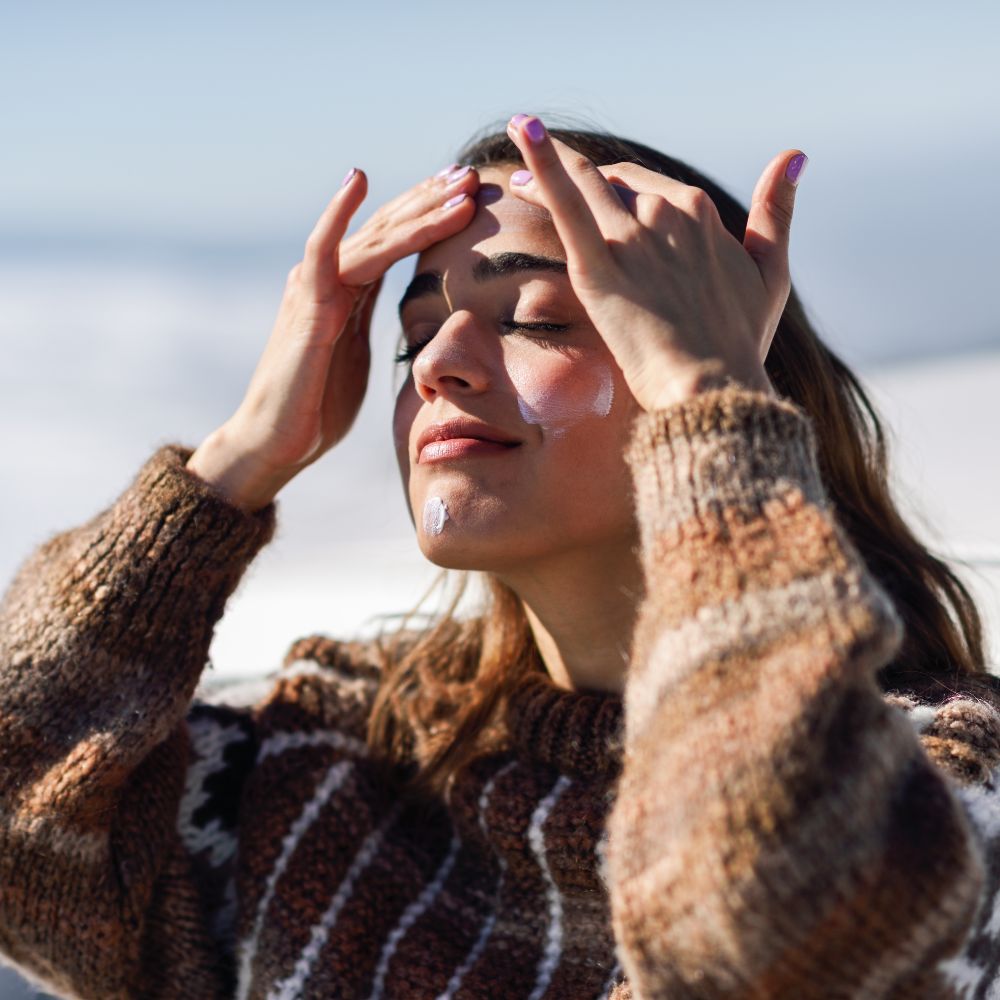 Jeune femme au soleil avec soin hydratant sur le visage